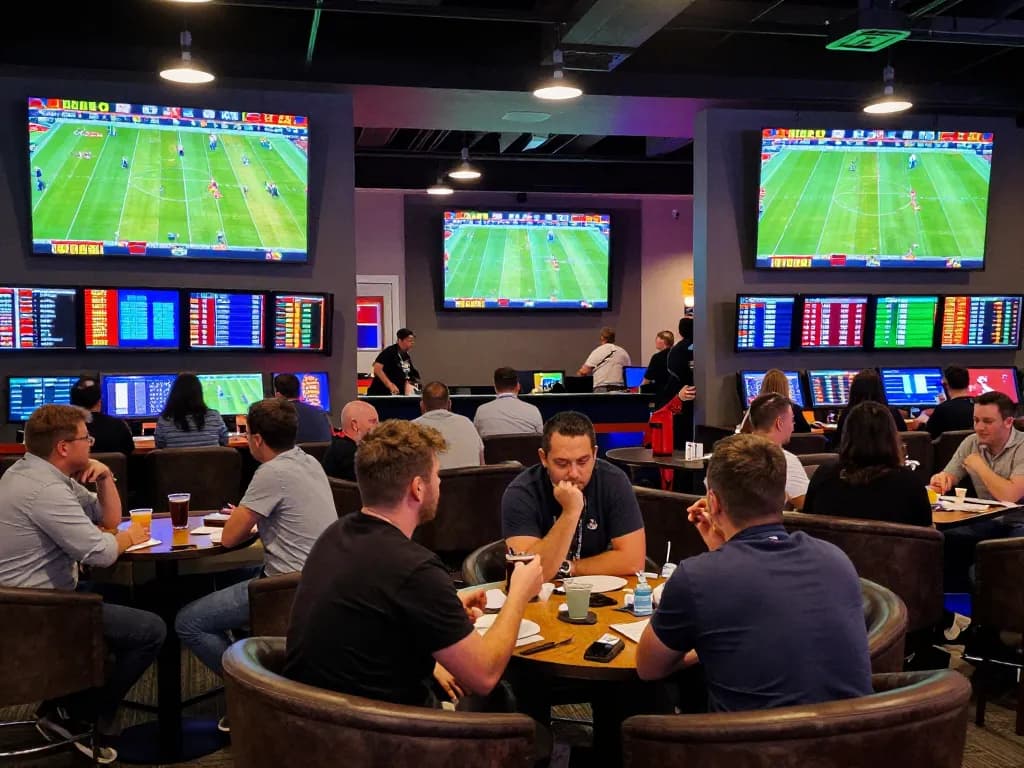 Engage in the excitement of ดูบอล at a lively sports betting lounge with multiple screens